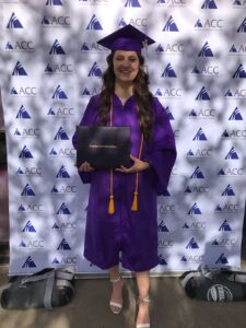 Sibria Bollman holds certificate at Arapahoe Community College graduation.
