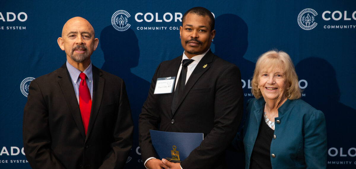 Mark Irby-Gill, center, accepts his Phi Theta Kappa All-Colorado Academic Team award from Colorado Community College System chancellor Joe Garcia and Red Rocks Community College president Michele Haney.
