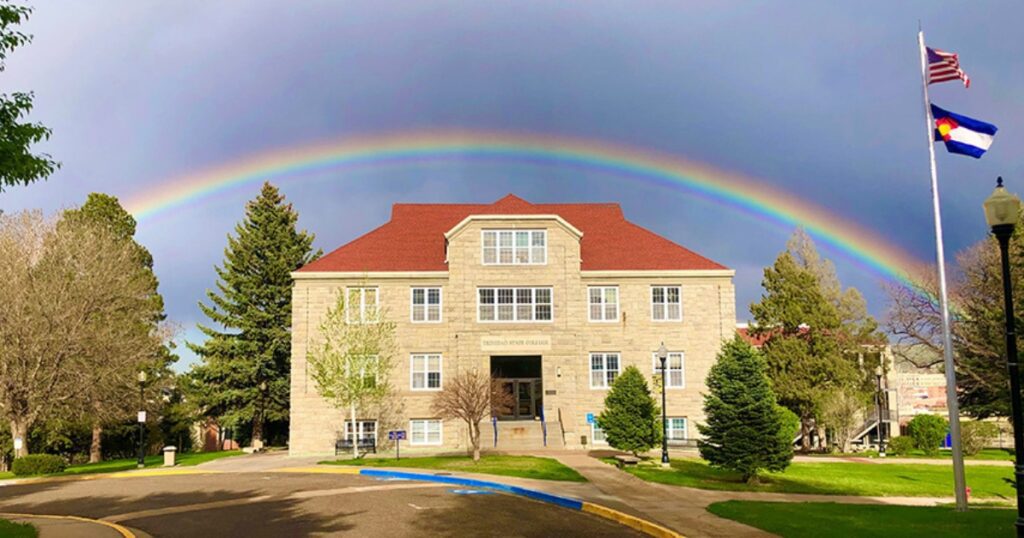 Trinidad State College Berg Administration Building with a rainbow in the background.
